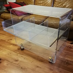 Meuble en plexiglas, design Michel Dumas. Une tablette coulissante munie de 3 tiroirs amovibles. Montage sur roulettes et taquets en métal doré. Largeur 72,5 cm, profondeur 40 cm, hauteur 68 cm. Quelques rayures d'usage.  450 €